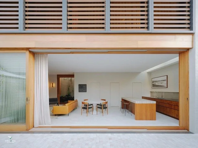 Finished rear living area through timber-framed doors at the Queens Park renovation