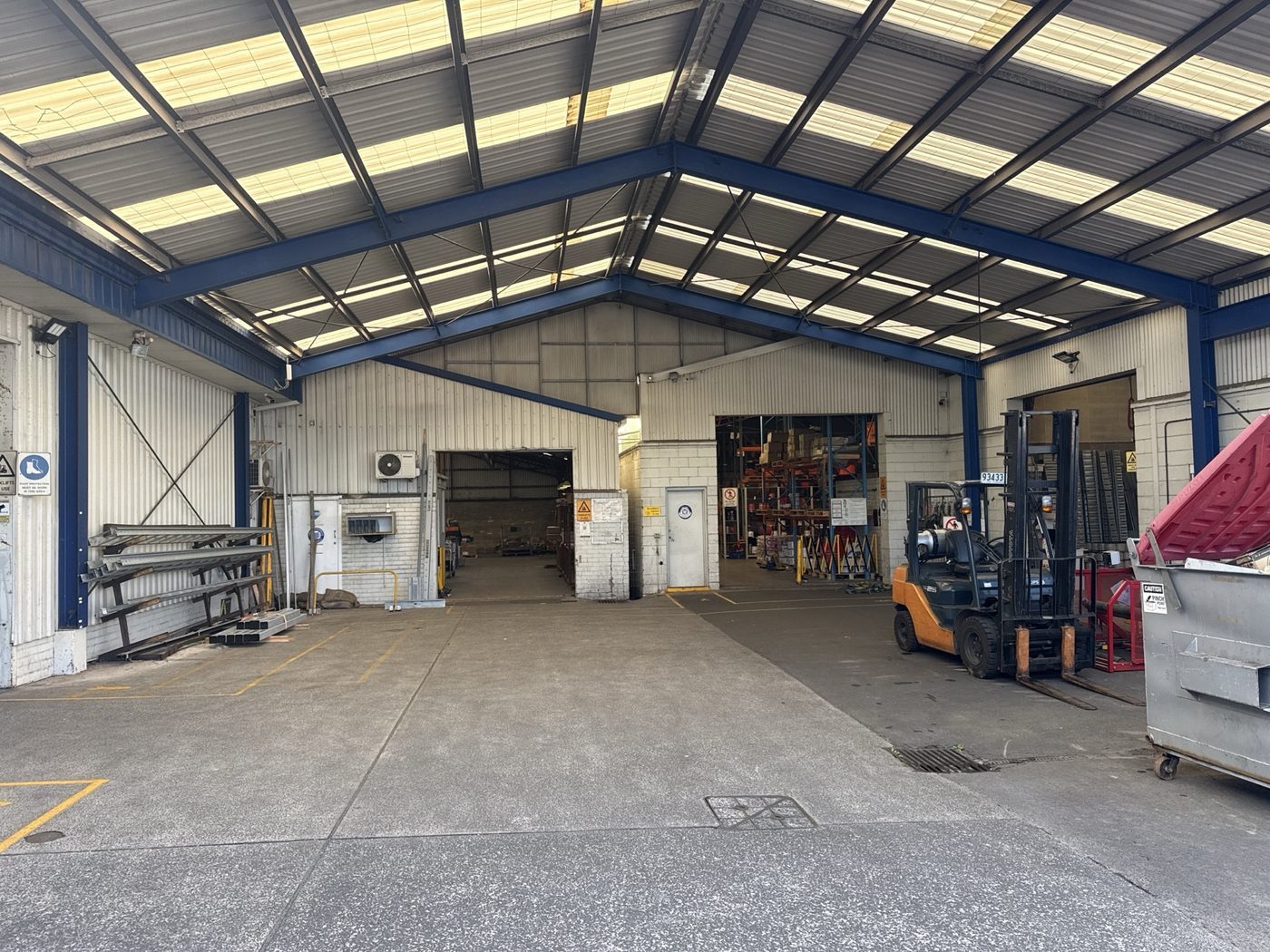 Before — bare warehouse bays in white and unpainted blockwork